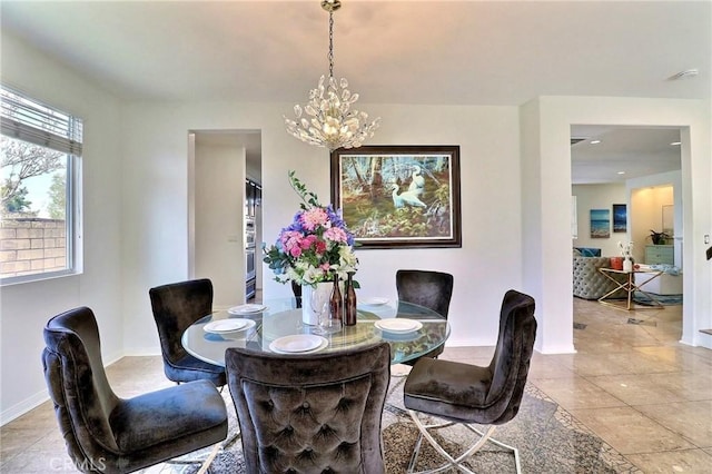 tiled dining space with a chandelier