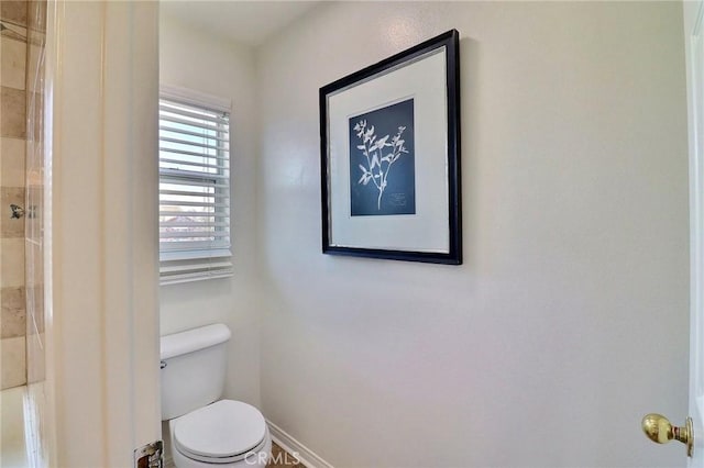 bathroom with a tile shower and toilet