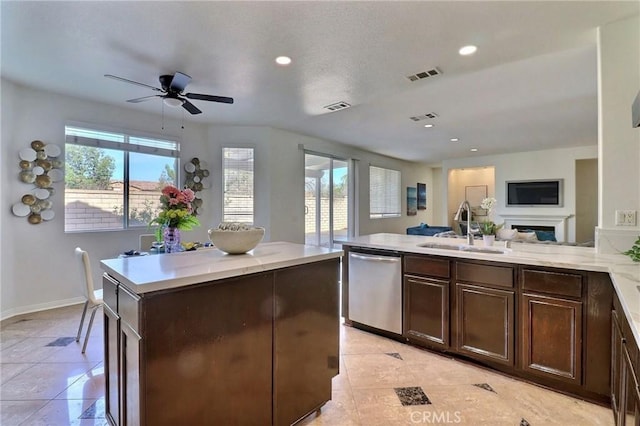 kitchen featuring sink, a center island, stainless steel dishwasher, light tile patterned floors, and dark brown cabinetry