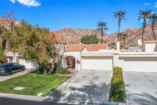 view of front of home featuring a mountain view, a front lawn, and a garage