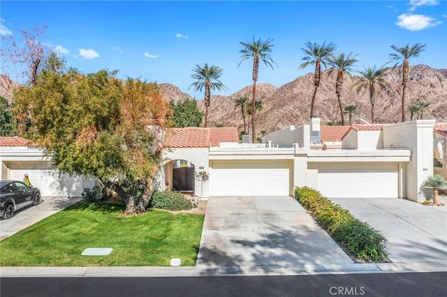 view of front facade featuring concrete driveway, a mountain view, and stucco siding