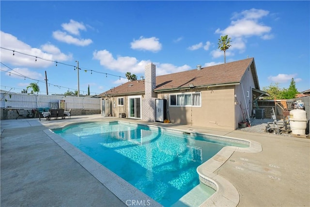 view of swimming pool with cooling unit and a patio