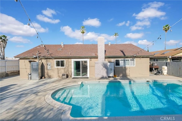 back of property featuring a fenced in pool and a patio