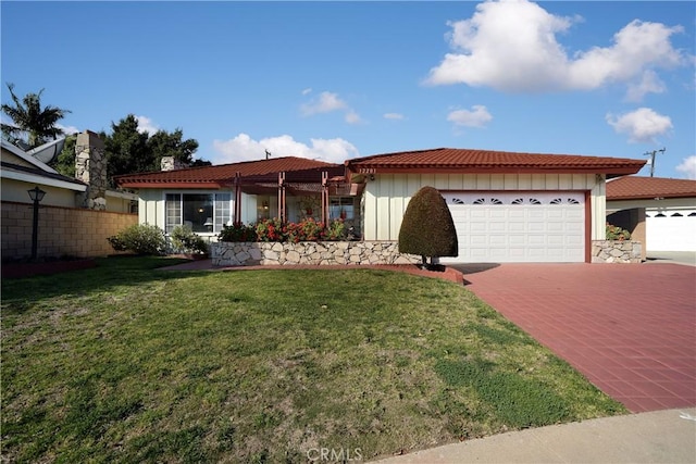 ranch-style house featuring decorative driveway, board and batten siding, fence, a garage, and a front lawn