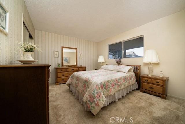 bedroom with light carpet and wallpapered walls