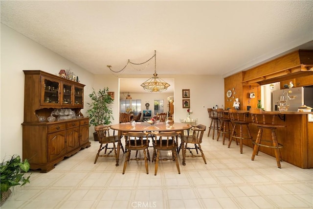 dining area with bar, a notable chandelier, and light floors