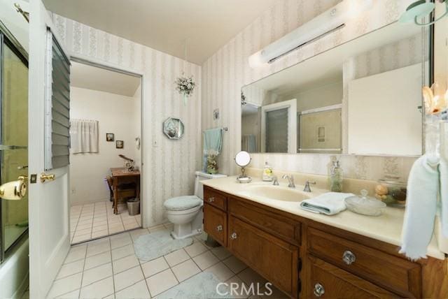 full bathroom featuring wallpapered walls, toilet, tile patterned floors, an enclosed shower, and vanity