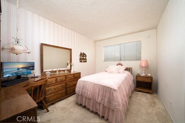 bedroom featuring light colored carpet and a textured ceiling