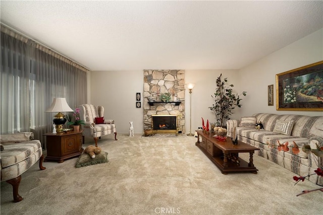 carpeted living area featuring a stone fireplace and a textured ceiling