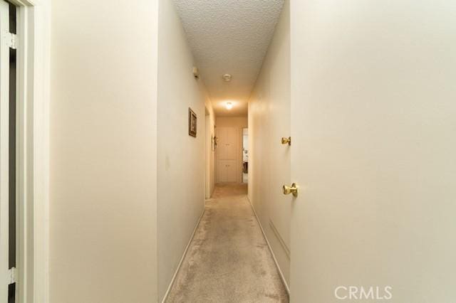 hallway featuring baseboards and a textured ceiling