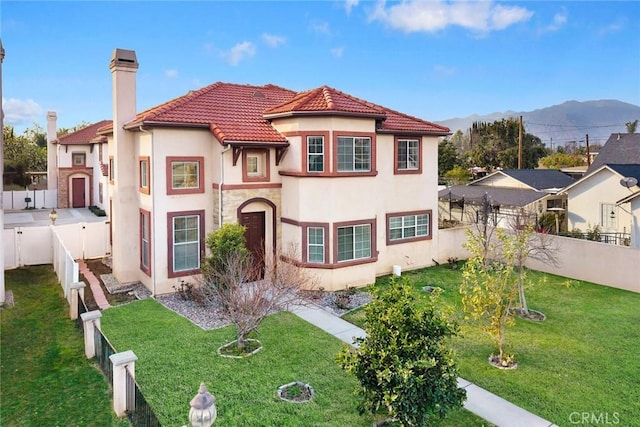 mediterranean / spanish-style house featuring a mountain view and a front yard