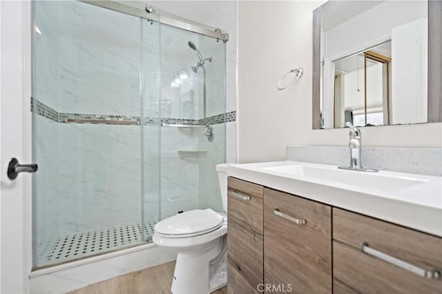 bathroom with vanity, toilet, and a shower with door