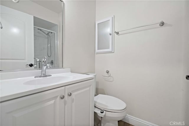 bathroom with walk in shower, vanity, and toilet