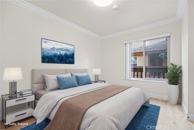 bedroom with ornamental molding and light hardwood / wood-style floors