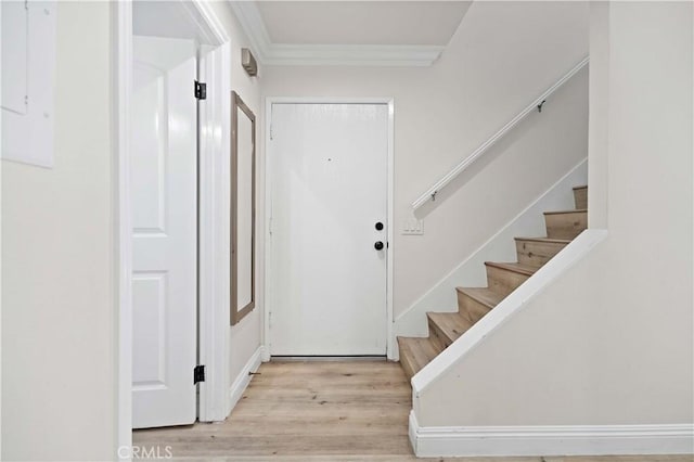 foyer with crown molding and light wood-type flooring