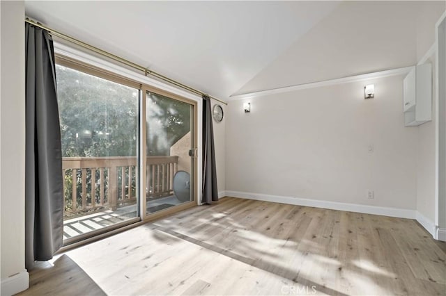 empty room featuring vaulted ceiling and light wood-type flooring