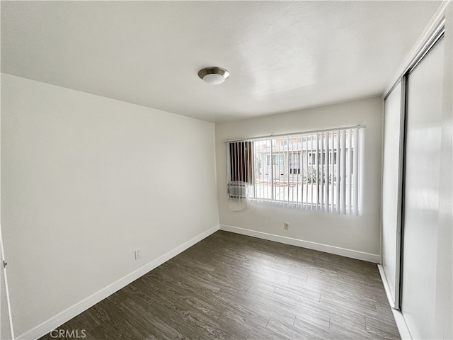 unfurnished bedroom featuring dark wood-type flooring and a closet