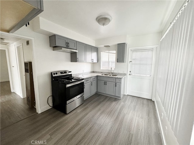 kitchen featuring stainless steel electric stove, sink, light hardwood / wood-style flooring, and gray cabinetry