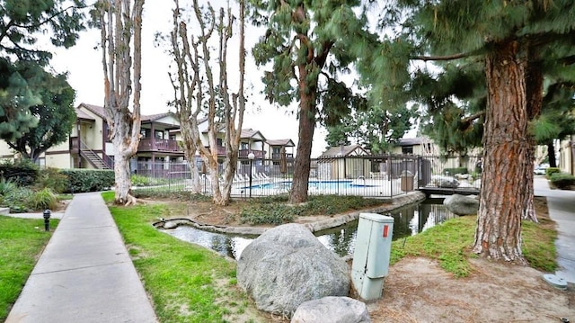 view of property's community featuring a water view and a pool