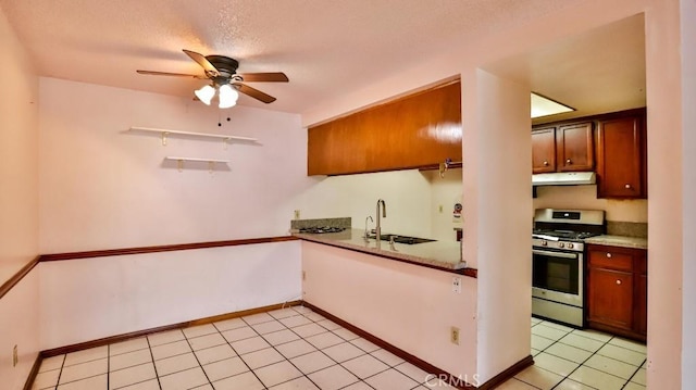 kitchen with sink, gas stove, a textured ceiling, light tile patterned floors, and ceiling fan