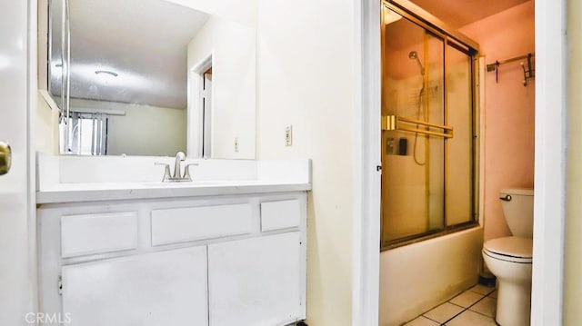 full bathroom with tile patterned floors, toilet, combined bath / shower with glass door, and vanity