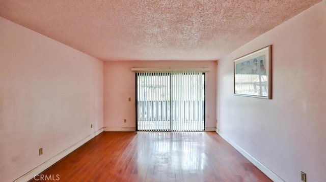 spare room with hardwood / wood-style flooring and a textured ceiling