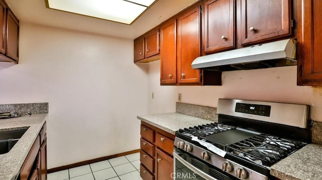 kitchen featuring sink, stainless steel range with gas stovetop, and light tile patterned floors