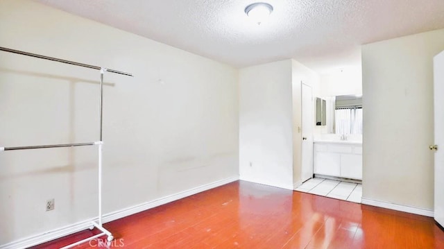 empty room with a textured ceiling and light wood-type flooring