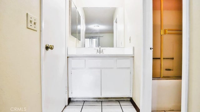 bathroom featuring vanity, combined bath / shower with glass door, and tile patterned floors