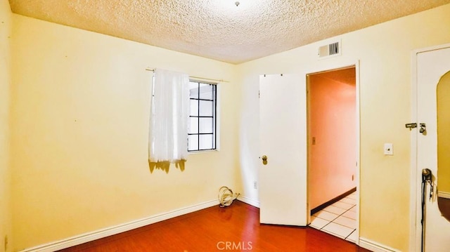 empty room featuring light hardwood / wood-style flooring and a textured ceiling