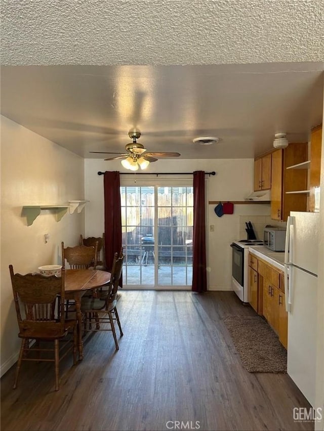 kitchen with ceiling fan, dark wood-type flooring, a textured ceiling, and white appliances