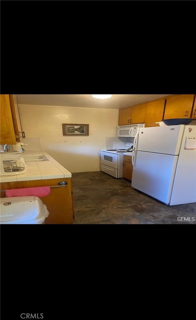 kitchen featuring tile countertops and white appliances