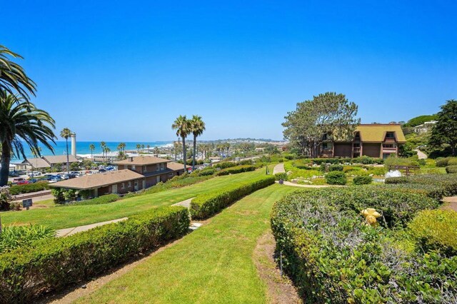 view of home's community featuring a lawn and a water view