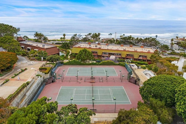 view of sport court with fence and a water view