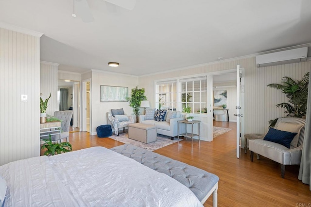 bedroom featuring ceiling fan, crown molding, wood finished floors, and a wall mounted AC