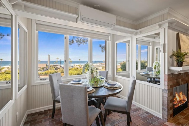 sunroom with brick floor, a wall mounted air conditioner, a water view, and crown molding