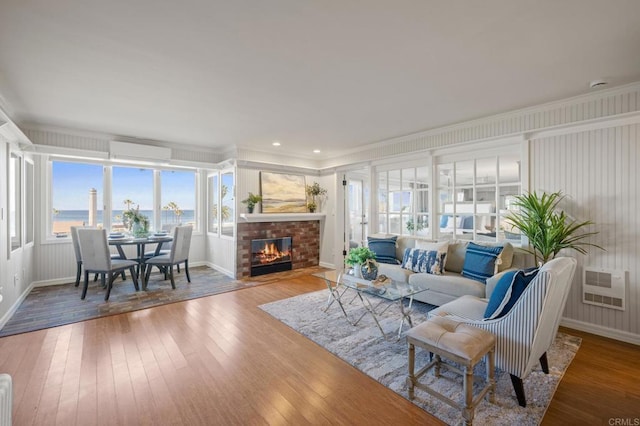 1562 Camino Del Mar Unit 440, Del Mar, CA 92014 - living area with ornamental molding, baseboards, hardwood / wood-style floors, a wall mounted air conditioner, and a brick fireplace