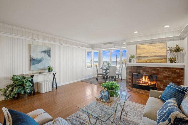 1562 Camino Del Mar Unit 440, Del Mar, CA 92014 - living room with ornamental molding, wood finished floors, a fireplace, an AC wall unit, and recessed lighting