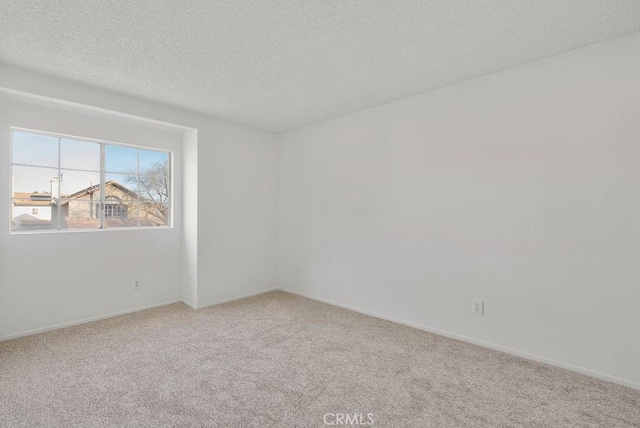 carpeted empty room featuring a textured ceiling