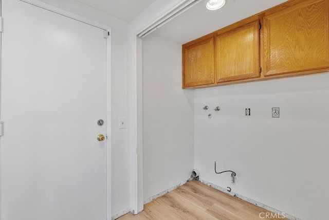 laundry room featuring cabinets, light hardwood / wood-style flooring, hookup for a washing machine, hookup for an electric dryer, and hookup for a gas dryer