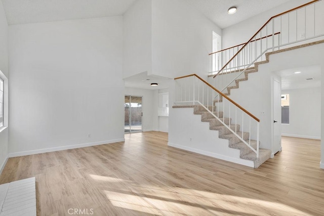 entryway with a towering ceiling and light hardwood / wood-style floors