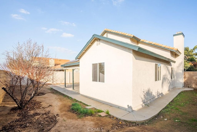 view of side of home with a patio