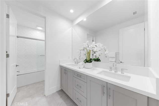 bathroom with vanity and shower / bath combination with glass door