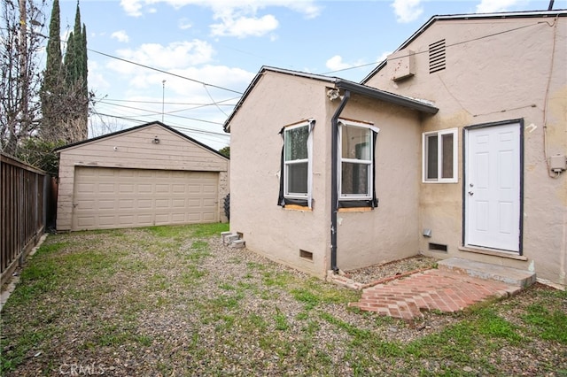 back of property featuring an outbuilding and a garage