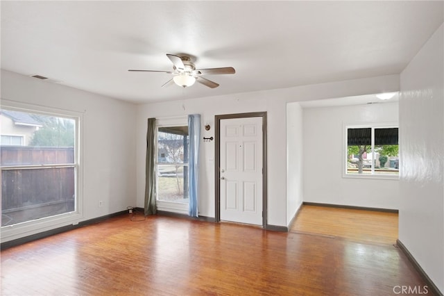 unfurnished room featuring wood-type flooring and a healthy amount of sunlight