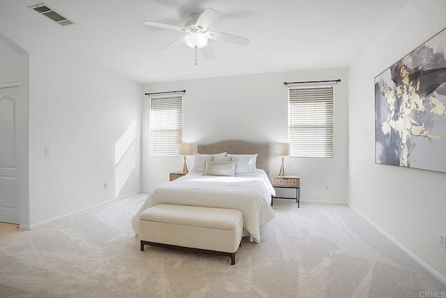 bedroom with multiple windows, light carpet, and ceiling fan