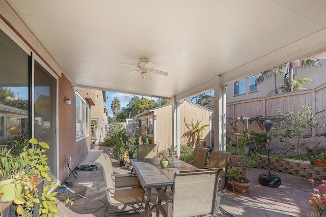 view of patio / terrace with ceiling fan and a storage unit