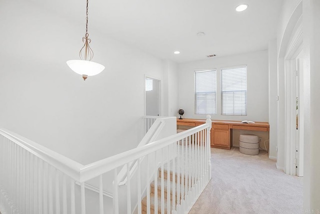 hall with light colored carpet