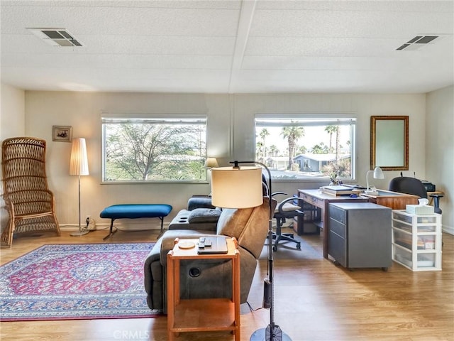 interior space with wood finished floors, visible vents, and baseboards