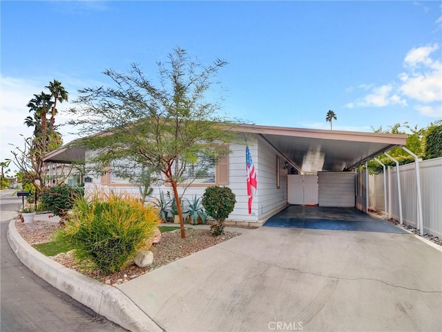 view of front of property with a carport, fence, and driveway